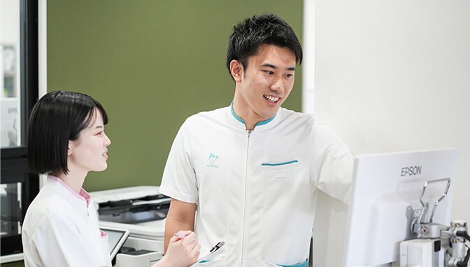 男性の薬剤師が女性のメディカルスタッフに処方する薬を説明