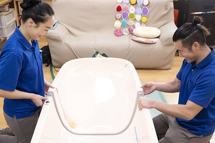 防水シートの上に置いたバスタブを組み立てる