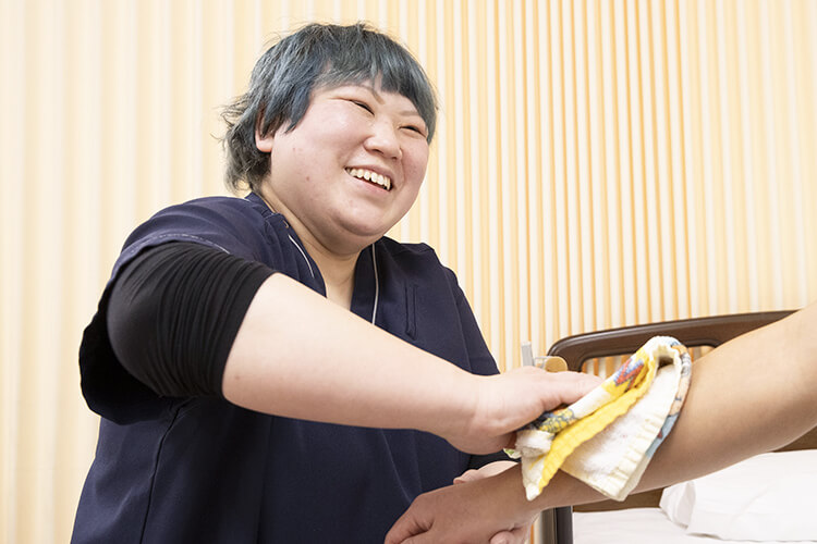 ご利用者様の身体をタオルで拭く介護士